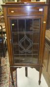 An early 20th Century mahogany and inlaid corner cupboard with single lead glazed door opening to