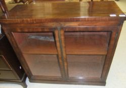 An early 19th century mahogany side cabinet, the plain top above two glazed doors enclosing a single