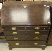 An oak four drawer bureau with brass handles, raised on bracket feet