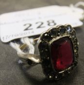 A 9 carat gold and silver mounted dress ring with central rectangular cut ruby style paste stone