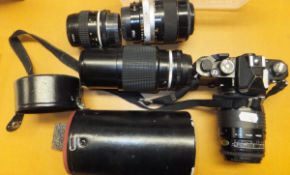 A Nikon FM camera body and various lenses to include Nikon, Nikon A1 lens, Sigma 35-135 lens etc