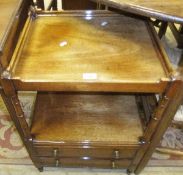 An early 20th Century mahogany two tier side table with two drawers on turned and ringed supports