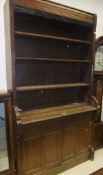 A Victorian oak bookcase cabinet with open adjustable shelving over two cupboard doors
