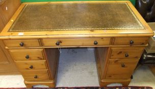 A modern reproduction pine kneehole desk, the rectangular top with tooled and gilded leather