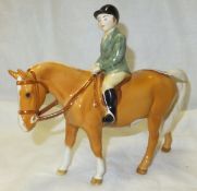 A Beswick pottery figure of a boy on a pony