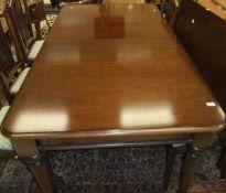 A modern mahogany dining table in the Regency taste, the rounded rectangular top with extra leaf
