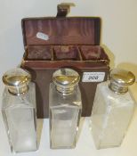 A set of three George V gentleman's cut glass bottles with silver lids, monogrammed "EJC" (London,