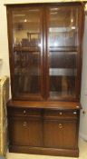 An illuminted Stag mahogany bookcase cabinet, the two glazed doors above two drawers and two