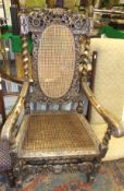 A heavily carved walnut framed hall chair with cane work seat and back in the Carolean taste