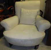 A circa 1900 armchair with cream damask upholstery, raised on turned and ringed legs to brass