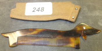A mid 20th Century faux tortoiseshell "Dachshund" comb with paste eye, housed in a dog coat style