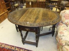 An 18th Century oak gate-leg drop-leaf dining table on turned and ringed supports with later