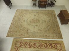 A machine made carpet with Aubusson style design in shades of cream, beige, terracotta and pale