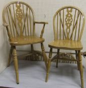 A set of four modern beech wheel back kitchen chairs together with a carver chair