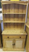 A small pine dresser, the plate rack above a single drawer over two panelled doors on a plinth base