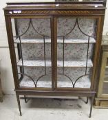 An Edwardian mahogany and inlaid display cabinet, the shaped cornice above two glazed doors