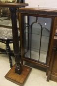 An early 20th Century mahogany display cabinet with single glazed door opening to reveal various
