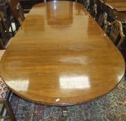 An early to mid 20th Century reproduction mahogany D end dining table on three central turned and
