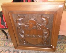 Two carved stained beech panels bearing armorial crests