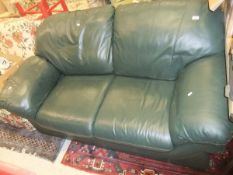 A green leatherette two seater sofa