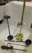 A brass lamp standard with circular base terminating in three feet, iron poker, set of scales, and