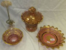 A cranberry glass lidded bowl on footed base with gilt decoration and one other matching bowl, a