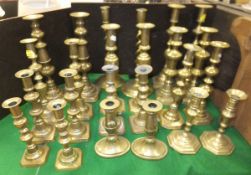 A collection of twelve pairs and a near-matching pair of brass candlesticks various