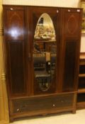 An Edwardian mahogany and inlaid wardrobe, the central mirrored door above a single drawer to