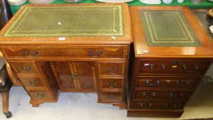 A modern reproduction yew wood and inlaid desk, the rectangular gilded leather top above a long
