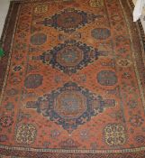 A Caucasian rug, the central panel set with three repeating blue medallions with stylised floral