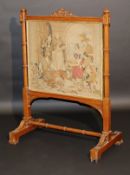 A Victorian carved oak framed fire screen in the Gothic Revival taste, the needlework panel