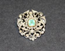 An early 19th Century white metal brooch set with central square cut emerald with white metal