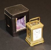 A circa 1900 French lacquered brass miniature carriage clock in an ogee case, the face with Roman