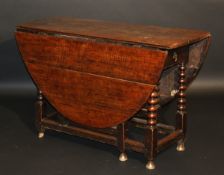 A late 17th Century oak oval gate leg drop leaf dining table with single end drawer on bobbin turned