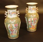 A pair of 19th Century Cantonese famille-rose vases of baluster form, the flared rims above gilt