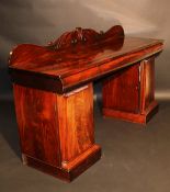 A late Regency/William IV mahogany pedestal sideboard, the raised foliate decorated back over