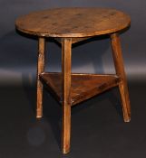 A 19th Century oak cricket table, the circular top on three splayed supports united by a pine