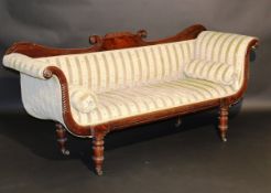 A Regency mahogany framed sofa in the Empire taste, the shaped back over an upholstered panel and