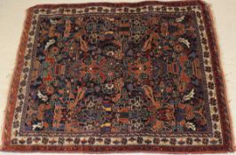 An Afshar rug, the central panel set with repeating floral pattern and bird motifs on a blue