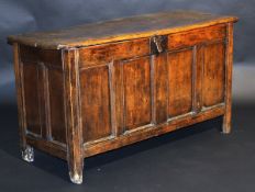 An 18th Century oak coffer, the single piece top with moulded edge over a plain frieze and four