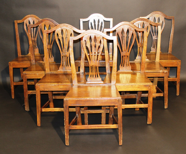 A set of eight late 18th Century provincial oak dining chairs, the serpentine top rails above a