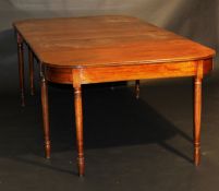 A Regency mahogany extending dining table, the rounded rectangular top with three extra leaves and
