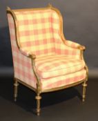 An early 20th Century carved giltwood and gesso framed salon wing back chair in the Louis XVI taste,