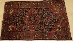 A Caucasian rug, the central panel set with lozenge shaped medallion decorated with floral motifs on