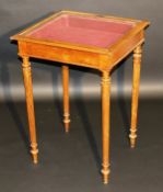 A circa 1900 mahogany bijouterie table, the glazed rising top with moulded edge raised on turned and