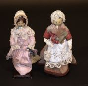 Two 18th Century painted wooden dolls; one dressed in jacket and shawl, with lace mop cap and