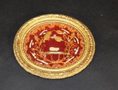 A 19th Century religious reliquary with quillwork decoration in orange and gilt on a red ground,