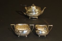 An Edwardian silver three piece tea set, inscribed "Presented to the Rev. W.B.D by the