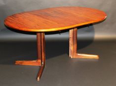 An early 1980's Danish rosewood D-end extending dining table, the top with extra leaf, raised on