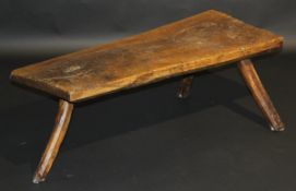 A 19th Century oak pig bench, the single piece top on three rough hewn splayed supports, 118 cm wide